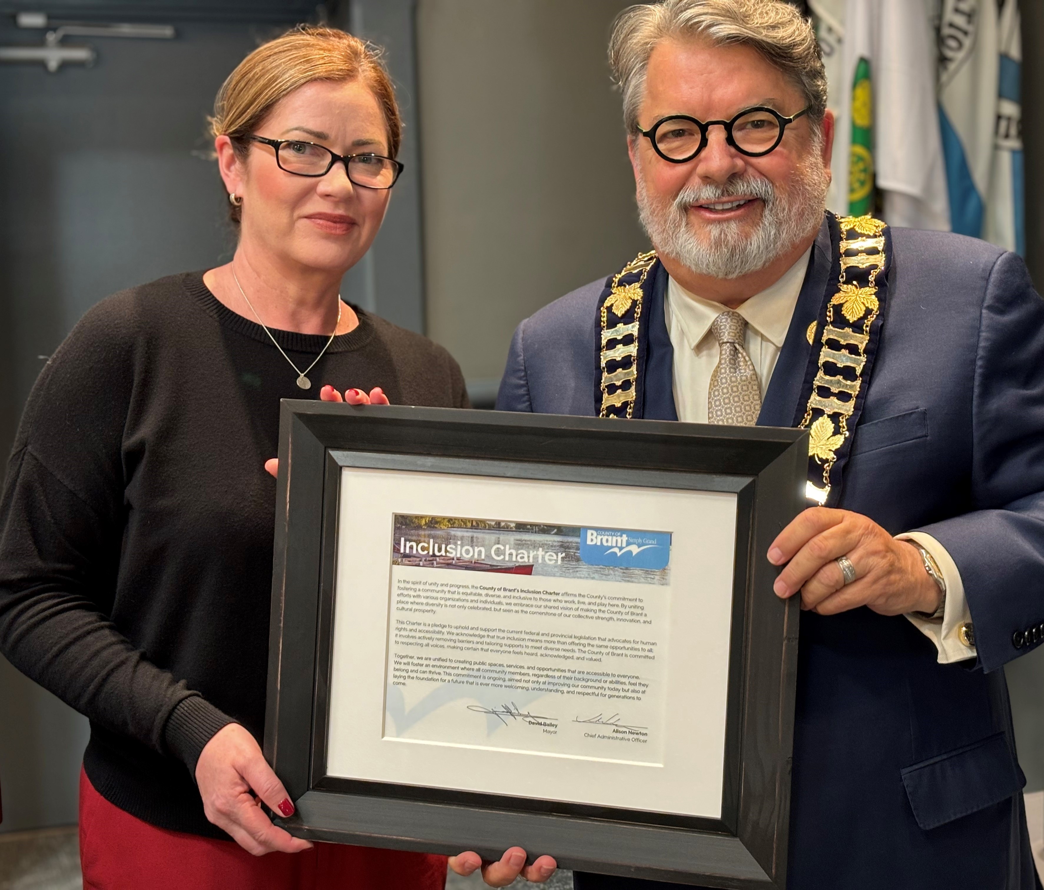 CAO Alison Newton and Mayor Bailey stand holding the signed inclusion charter